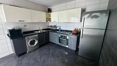 a kitchen with a refrigerator and a washing machine at La siesta beach resort Mohammedia vue mer panoramique in Mohammedia