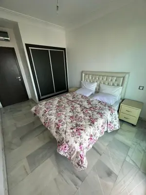 a bedroom with a bed with a floral comforter at La siesta beach resort Mohammedia vue mer panoramique in Mohammedia