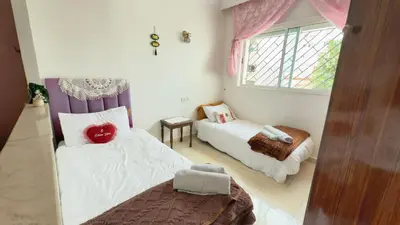 a small room with two beds and a window at Immense appartement familial vue sur mer in Rabat