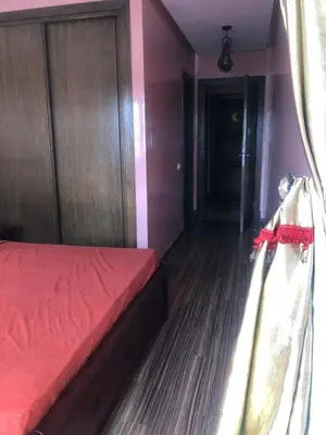a bedroom with a bed with a red comforter at Apartment Galia Mohammedia in Mohammedia