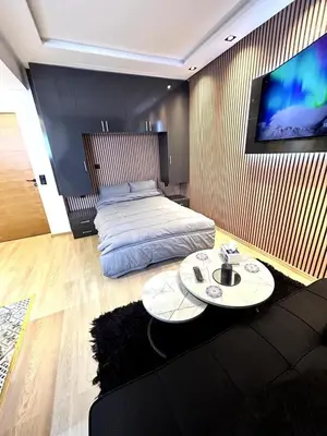 a room with two beds and a tv on a wall at Studio au Cœur de Rabat in Rabat