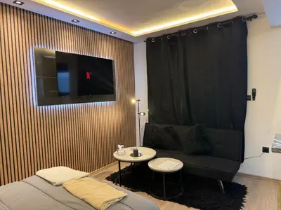 a living room with a couch and a tv on a wall at Studio au Cœur de Rabat in Rabat