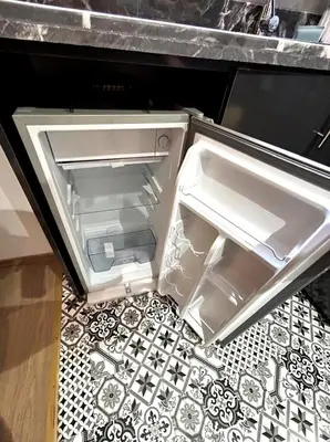 an open refrigerator with its door open on a kitchen floor at Studio au Cœur de Rabat in Rabat