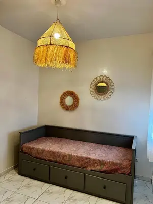 a bedroom with a bed and a chandelier and mirrors at An Elegant apartment, Quiet Stay with Moroccan Touch in Dar Bouazza