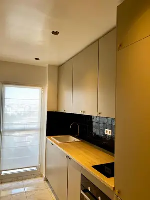 a kitchen with white cabinets and a sink at An Elegant apartment, Quiet Stay with Moroccan Touch in Dar Bouazza