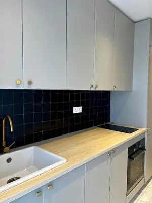 a kitchen with white cabinets and a sink at An Elegant apartment, Quiet Stay with Moroccan Touch in Dar Bouazza
