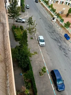 an aerial view of two cars parked in a parking lot at An Elegant apartment, Quiet Stay with Moroccan Touch in Dar Bouazza