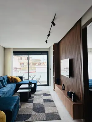 a living room with a blue couch and a tv at Premium Apt Casa City Center in Casablanca