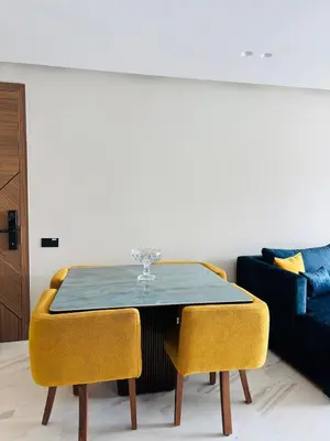 a dining room table with yellow chairs and a couch at Premium Apt Casa City Center in Casablanca