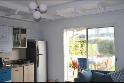 a kitchen with a refrigerator and a table with chairs at K Playa Vibe Darbouazza in Dar Bouazza