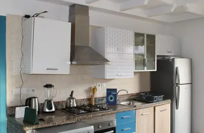 a kitchen with white cabinets and a stove top oven at K Playa Vibe Darbouazza in Dar Bouazza