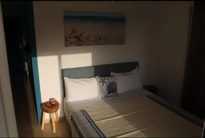 a bedroom with a bed and a small table at K Playa Vibe Darbouazza in Dar Bouazza