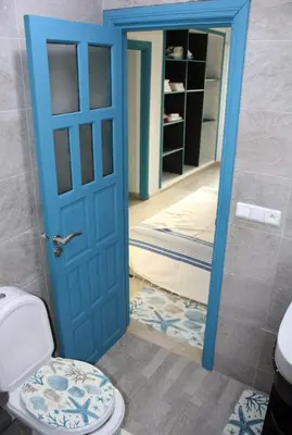 a bathroom with a blue door and a toilet at K Playa Vibe Darbouazza in Dar Bouazza