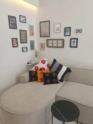 a room with a bed with pillows and pictures on the wall at Sunny Studio Apartment with Courtyard in Casablanca
