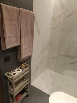 a bathroom with a shower and a toilet and towels at Sunny Studio Apartment with Courtyard in Casablanca
