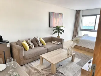 a living room with a couch and a table at 4-Marina Calma ocean-studio coconing vue mer in Casablanca