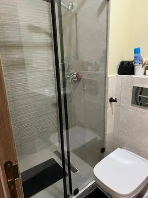 a bathroom with a shower and a toilet at Duplex Vue Piscine et Jardin Océan Park à Zenata City Eco in Aïn Harrouda