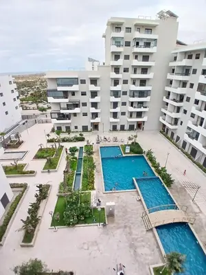 an aerial view of a building with two pools at Duplex Vue Piscine et Jardin Océan Park à Zenata City Eco in Aïn Harrouda