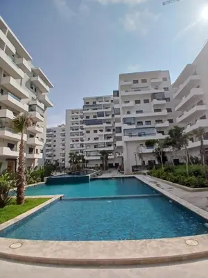 a swimming pool in front of some apartment buildings at Duplex Vue Piscine et Jardin Océan Park à Zenata City Eco in Aïn Harrouda