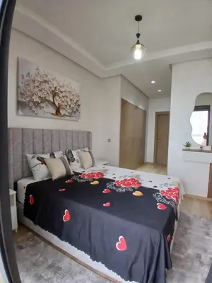 a bedroom with a bed with a black blanket with hearts on it at Duplex Vue Piscine et Jardin Océan Park à Zenata City Eco in Aïn Harrouda