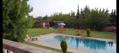 a swimming pool in a yard with chairs and a house at Farm Fields and Forests 20 min from carrefour berchid in Berrechid
