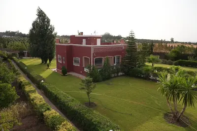 an aerial view of a red house with a yard at Farm Fields and Forests 20 min from carrefour berchid in Berrechid