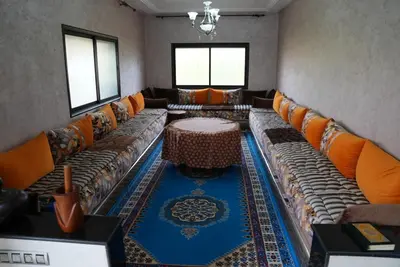 a living room with couches and a table on a rug at Farm Fields and Forests 20 min from carrefour berchid in Berrechid