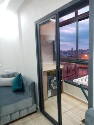 a room with a couch and a balcony with a view at Perle Bouznika in Bouznika