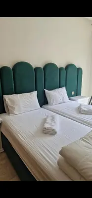 a large bed with a green headboard in a room at Appartement cosy près Abdelmoumen Maarif in Casablanca