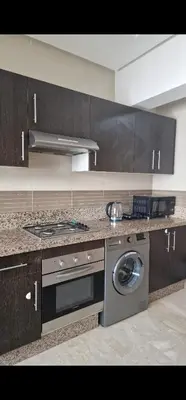 a kitchen with a stove and a washing machine at Appartement cosy près Abdelmoumen Maarif in Casablanca