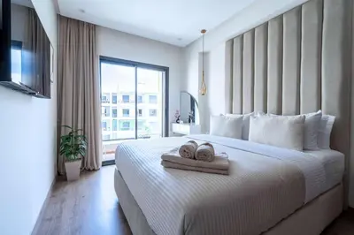 a bedroom with a large bed with two towels on it at Elegant Comfort Pool Gym & Kids Club in Mohammedia