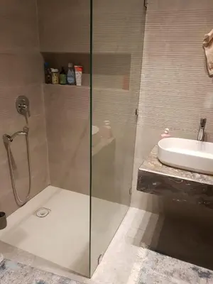 a bathroom with a glass shower and a sink at Luxury apartment in Oulad Mbark