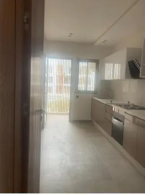 a kitchen with a door open to a kitchen with a sink at Luxury apartment in Oulad Mbark