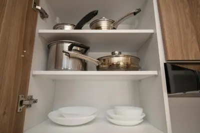 a pantry with dishes and pots and pans on shelves at plénitude in Mohammedia