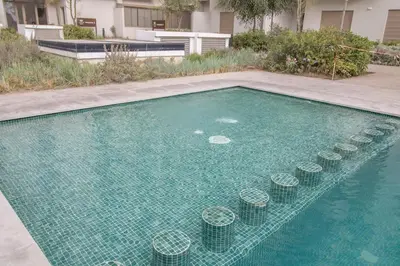 a swimming pool with green tiles in the water at plénitude in Mohammedia