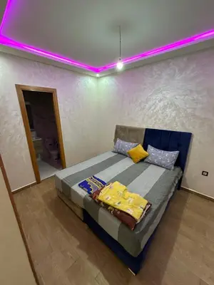 a bedroom with a bed with a purple lighting at Apparemment propre pour les familles in Casablanca