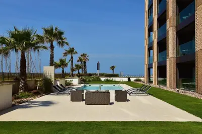 a swimming pool with lounge chairs and a building at Ocean View 2 Bedroom Apartment in Casablanca