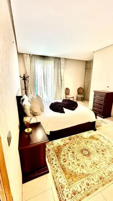 a bedroom with a large bed and a rug at Ocean View 2 Bedroom Apartment in Casablanca