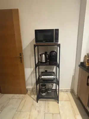 a television and a microwave on a shelf in a room at Luxury apartment with sea view and 2 pools Sablettes in Mohammedia