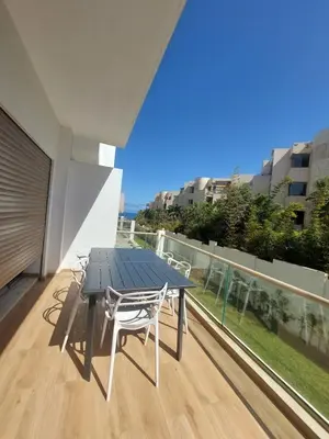 a table and chairs on a balcony with a view at Luxury apartment with sea view and 2 pools Sablettes in Mohammedia