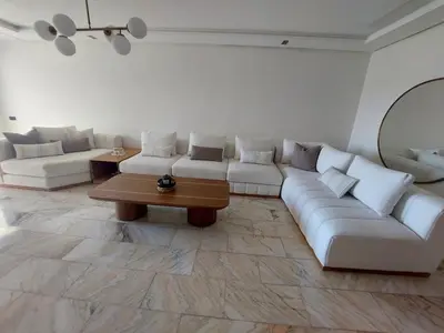 a living room with a white couch and a table at Luxury apartment with sea view and 2 pools Sablettes in Mohammedia