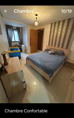 a bedroom with a bed and a table in it at Hébergement idéal pour conjuguer tourisme, affaires et télétravail in Mohammedia