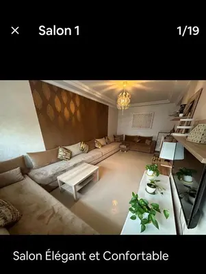 a living room with a couch and a table at Hébergement idéal pour conjuguer tourisme, affaires et télétravail in Mohammedia
