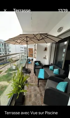 a living room with couches and an umbrella at Hébergement idéal pour conjuguer tourisme, affaires et télétravail in Mohammedia