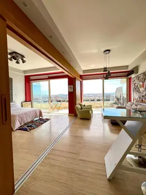 a bedroom with a bed and a table and some windows at Terrace & View of Casablanca Port in Casablanca