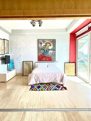 a bedroom with a bed and a painting on the wall at Terrace & View of Casablanca Port in Casablanca