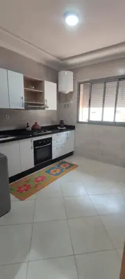 a kitchen with white cabinets and a rug on the floor at Résidence Sable Dor in Mohammedia
