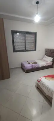 a white room with two beds and a window at Résidence Sable Dor in Mohammedia