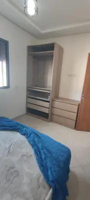 a bedroom with a bed with a blue blanket on it at Résidence Sable Dor in Mohammedia
