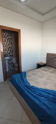a bedroom with a bed in a room with a door at Résidence Sable Dor in Mohammedia
